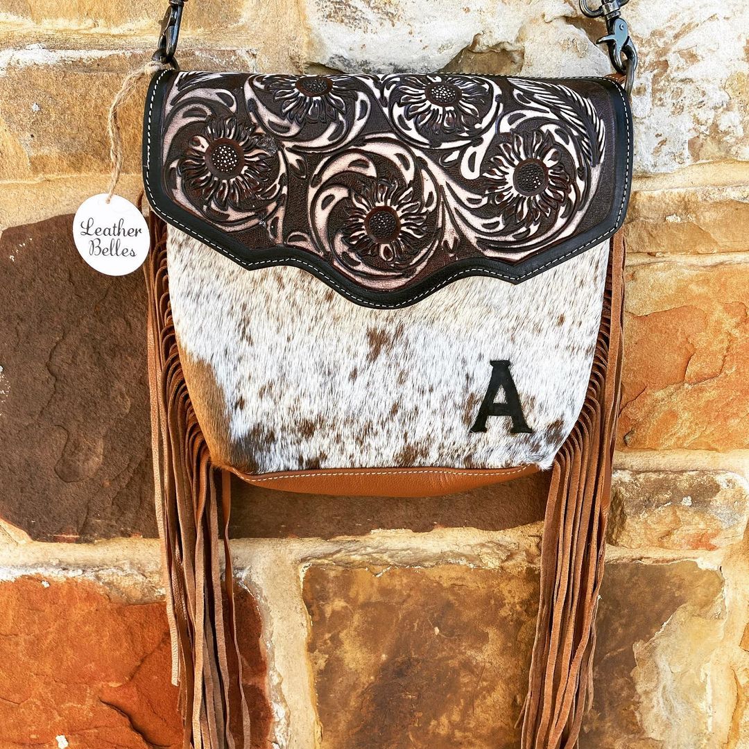 black and white leather handbag with carved flower pattern and white fur and long leather frindge